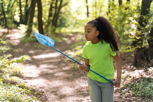 Foto gratuita bambino che esplora la foresta il giorno dell'ambiente