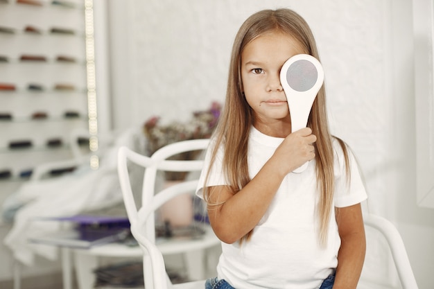 Free photo child eye test and eye exam. little girl having eye check-up, with phoropter. eye test for children