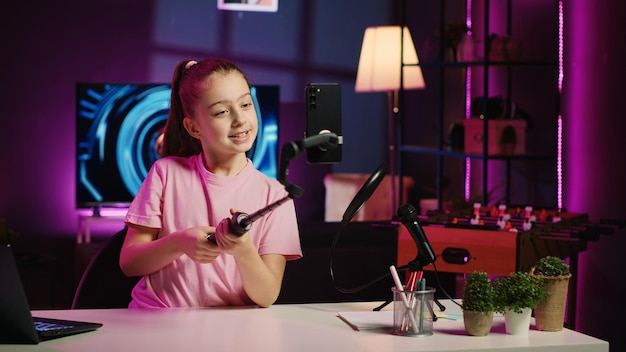 Ребенок снимает видео с телефона, прикрепленного к палке для селфи, для общения онлайн-канала со зрителями