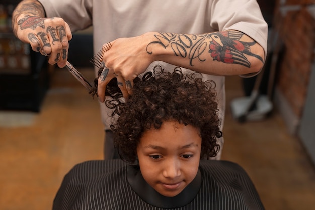 Foto gratuita bambino che ottiene un taglio di capelli al salone