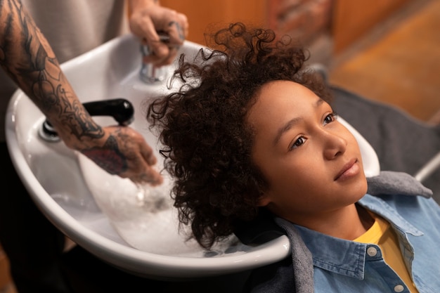 Foto gratuita bambino che si lava i capelli al salone