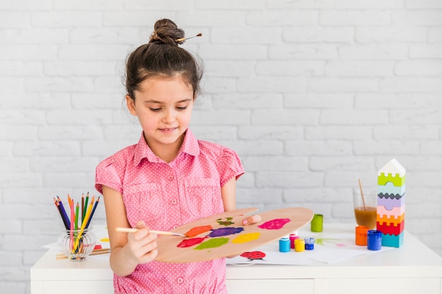 A child girl artist mixing the watercolor on palette