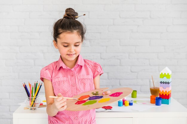 パレット上の水彩画を混合する子供女の子アーティスト