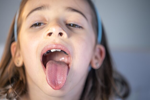 A child girl open her mouth and show her tounge