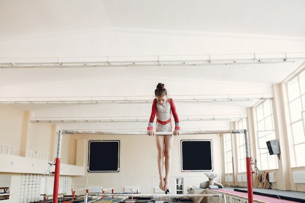 Бесплатное фото Бревно-балансир детской гимнастики. спортсменка гимнастка во время турника упражнения в соревнованиях по гимнастике.