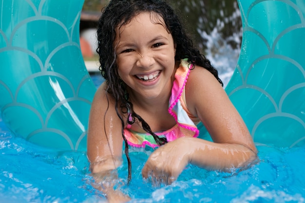 Foto gratuita bambino che si diverte con il galleggiante in piscina