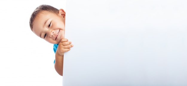 Free photo child hiding behind a white poster