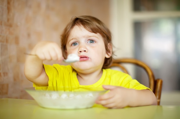 Free photo child himself eats  with spoon