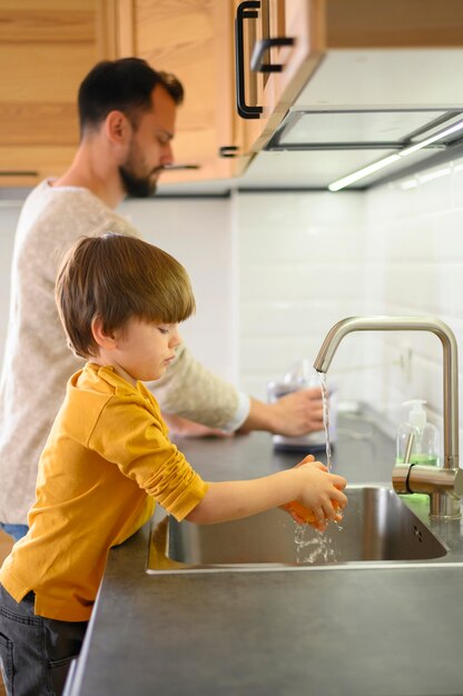 Child and his father washing lemons
