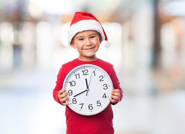 Child holding a clock in front of his chest