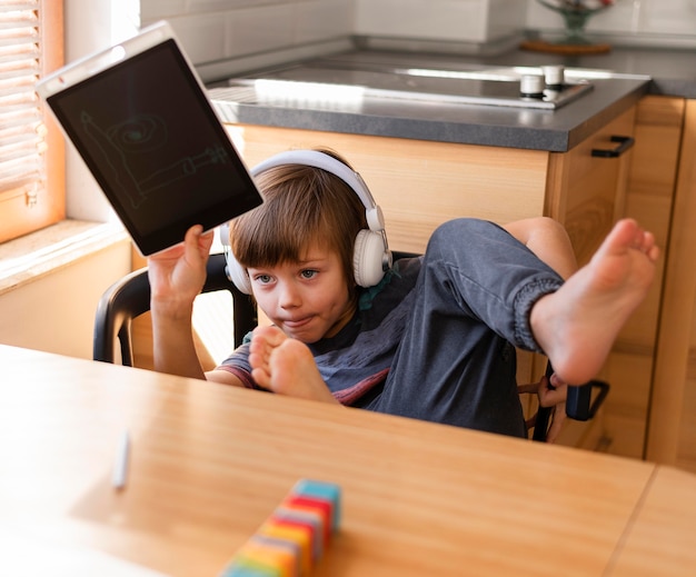 Child holding a drawing online school interactions
