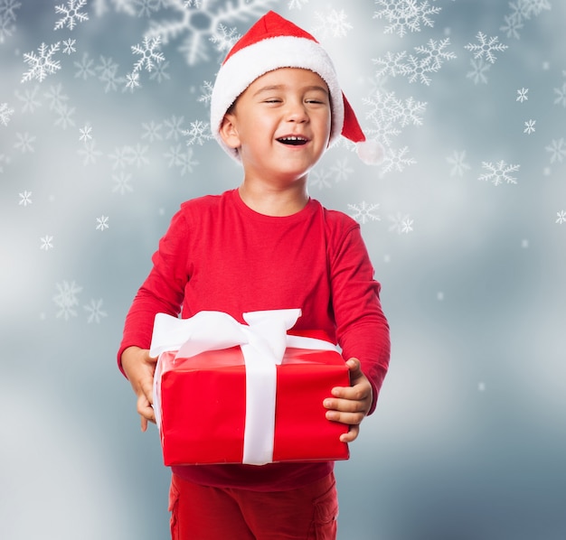 Child holding a gift with snowflakes background