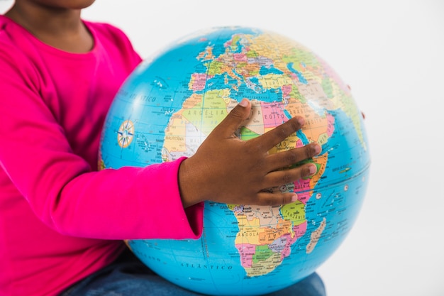 Free photo child holding globe in studio