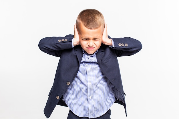 Child holding his hands against his ears a over white wall