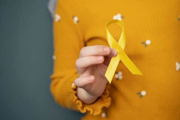 Child holding yellow ribbon