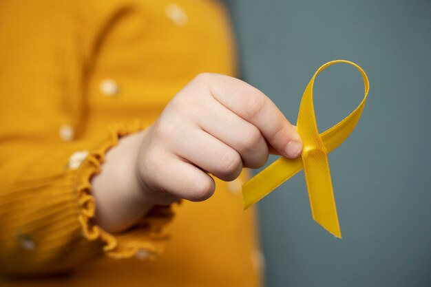 Child holding yellow ribbon