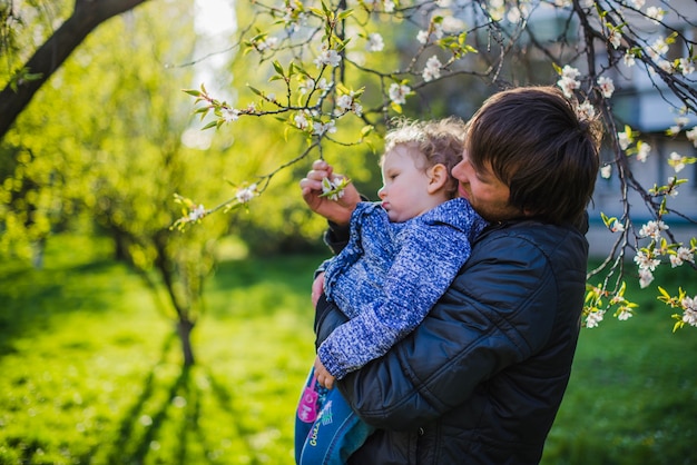 Foto gratuita bambino che guarda un ramo in fiore