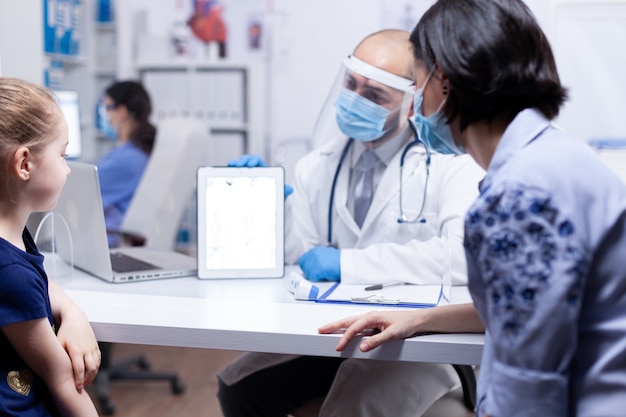 Child and mother at doctor appointment during global pandemic with coronavirus