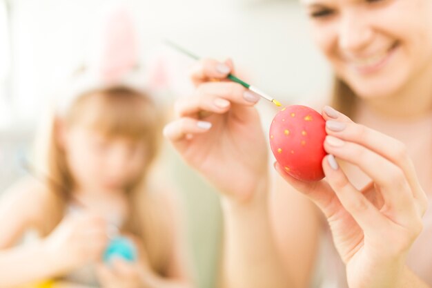 Child and mother painting Easter eggs
