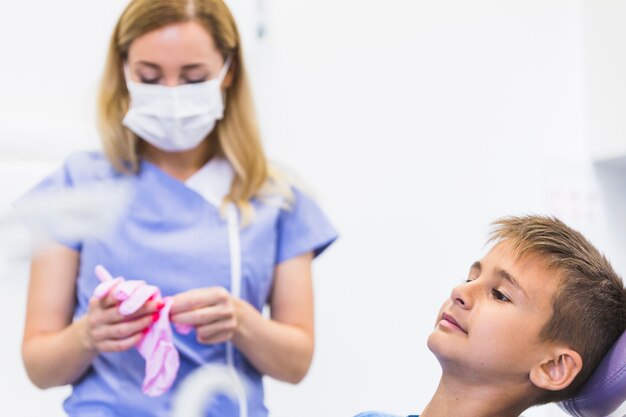 Child patient in front of female dentist wearing gloves