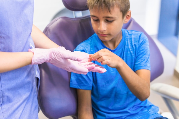 여성 치과 의사 손에서 약을 복용하는 어린이 환자