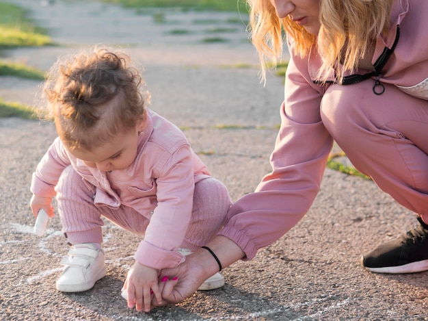 Child in pink clothes and mom drawing