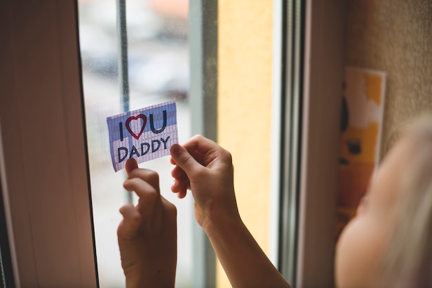 Child placing a note in the window for his father