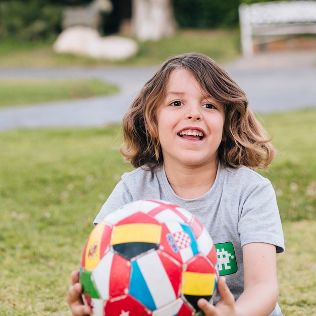 Foto gratuita bambino che gioca con un pallone da calcio