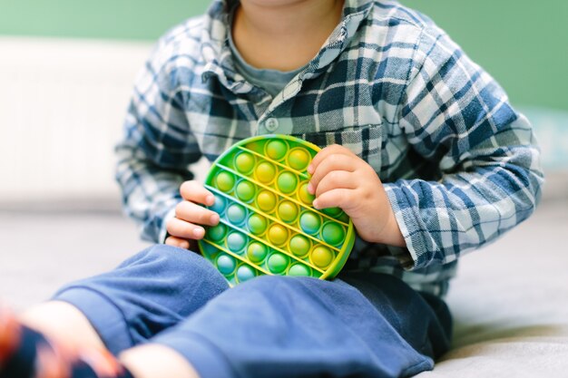 Premium Photo | Child playing with the pop it fidget. rainbow pop it fidget  toy