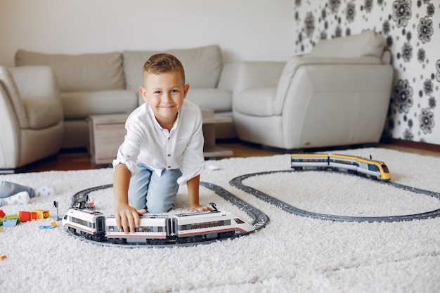 Child playing with toy train in a playing room