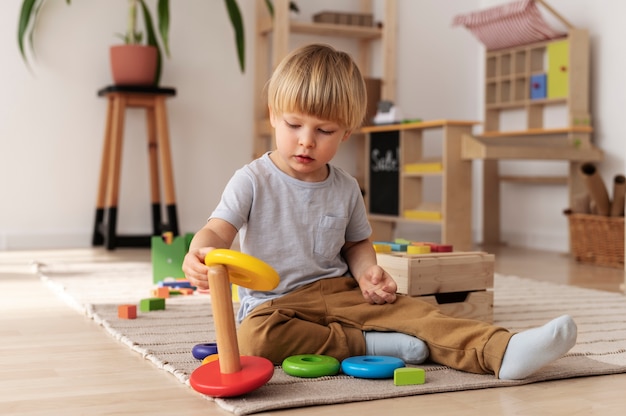 Ребенок играет с деревянными игрушками в полный рост