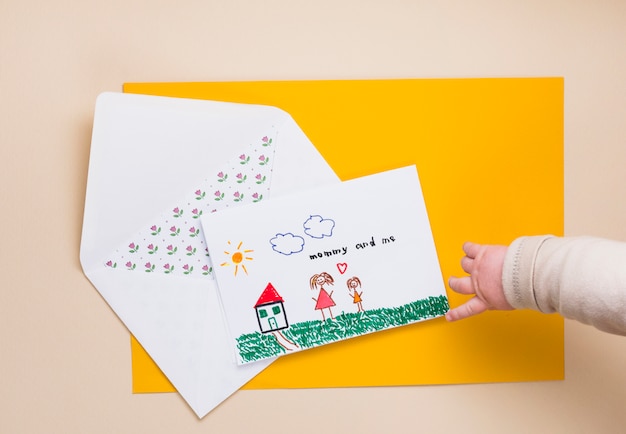 Free photo child pointing finger at drawing of mother and kid