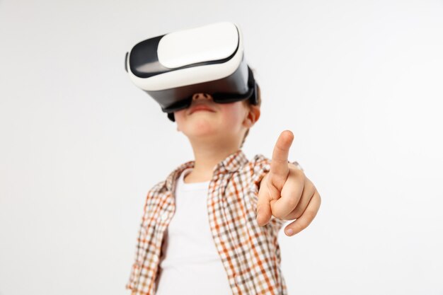 Ребенок, указывая вперед с изолированными очками виртуальной реальности
