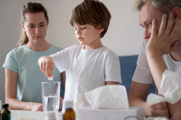 Child putting a pill into a glass of water