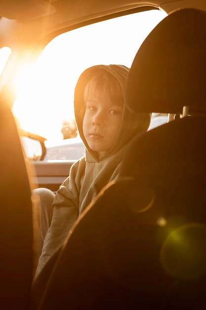 太陽光線で車の中でロードトリップの子供