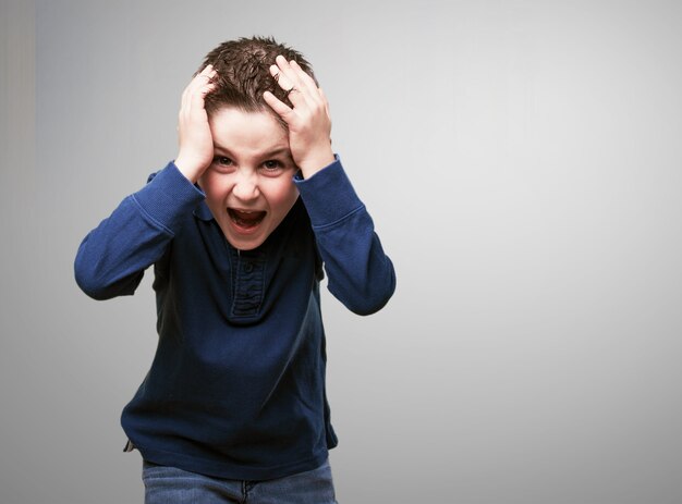 Child screaming with hands on head