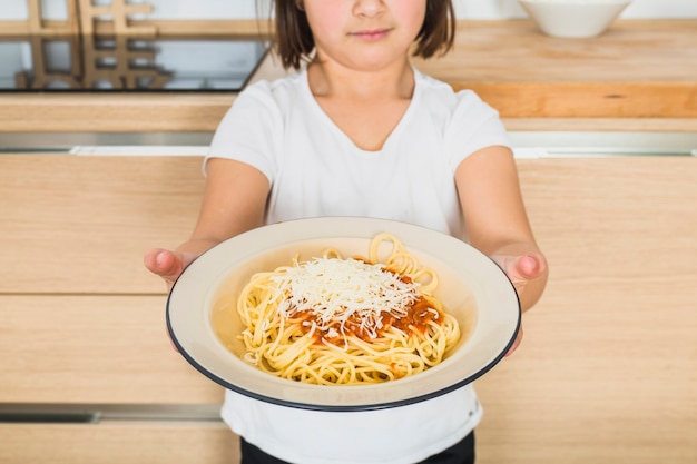 Free photo child showing plate with pasta