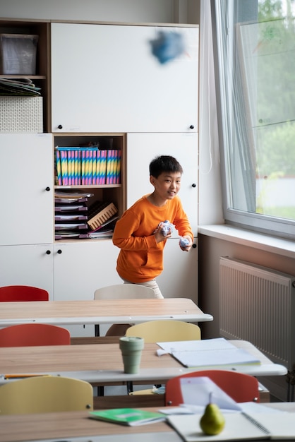 Foto gratuita studente bambino che gioca a scuola