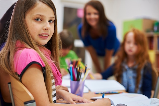 Foto gratuita studente bambino seduto alla sua scrivania