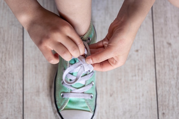 Ребенок успешно завязывает обувь крупным планом на ногах