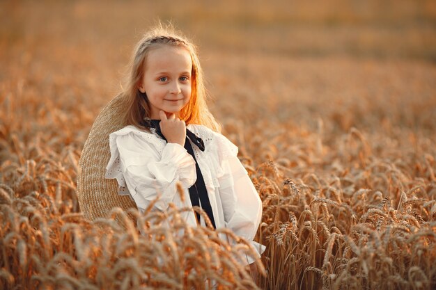 Child in a summer field. Little girl in a cute white dress.