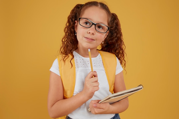 Child thinking and holding notebook