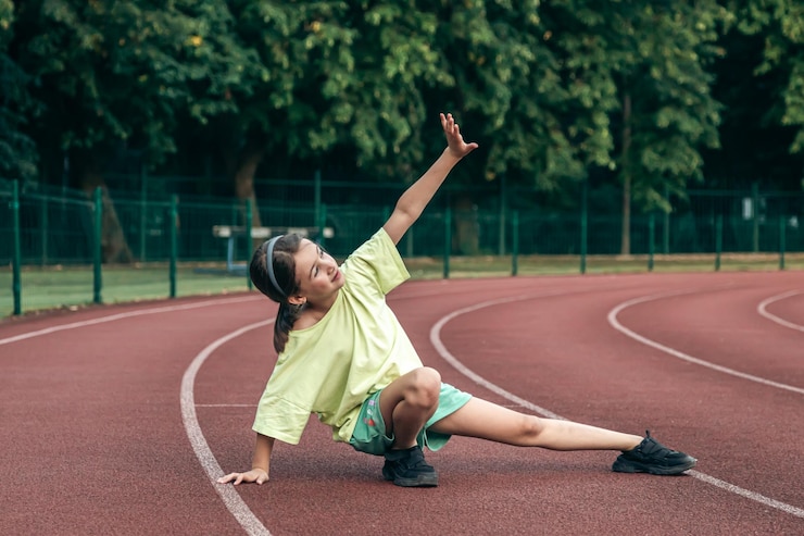無料Photo 学校の体育の授業でトレーニングする子供の屋外でストレッチする 10 代の少女