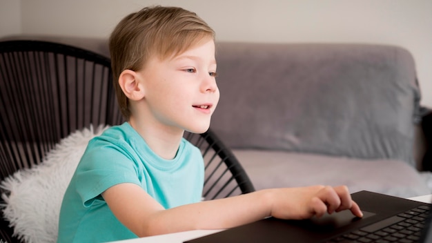 Child using his laptop indoors