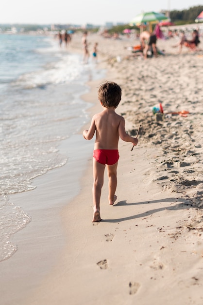 뒤에서 해변을 따라 걷는 아이