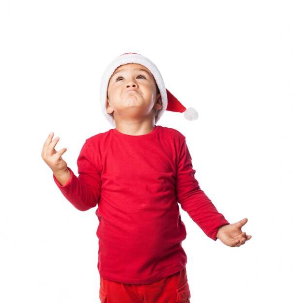 Child wearing christmas hat with confusion gestures