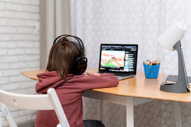 Foto gratuita bambino che indossa le cuffie che frequentano corsi online