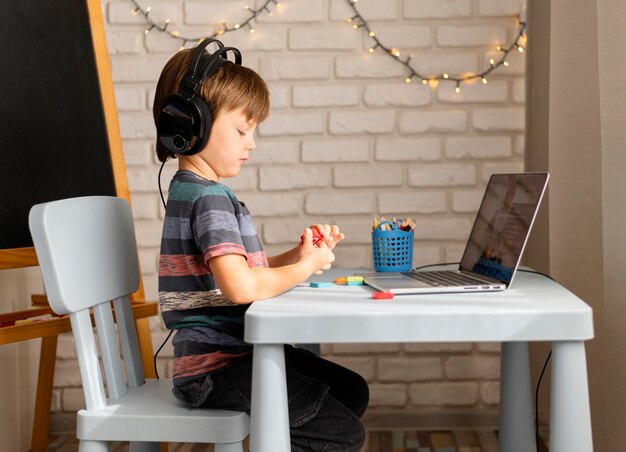 Child wearing headphones attending online courses