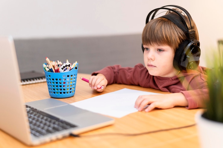 मुफ़्त फोटो child wearing headphones attending online school