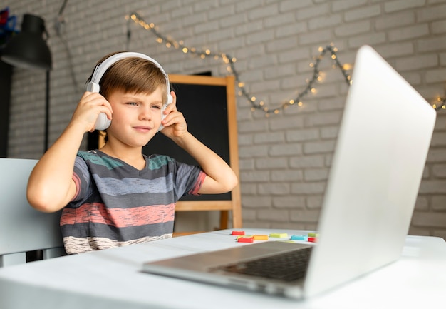 Child wearing headphones attending virtual classes
